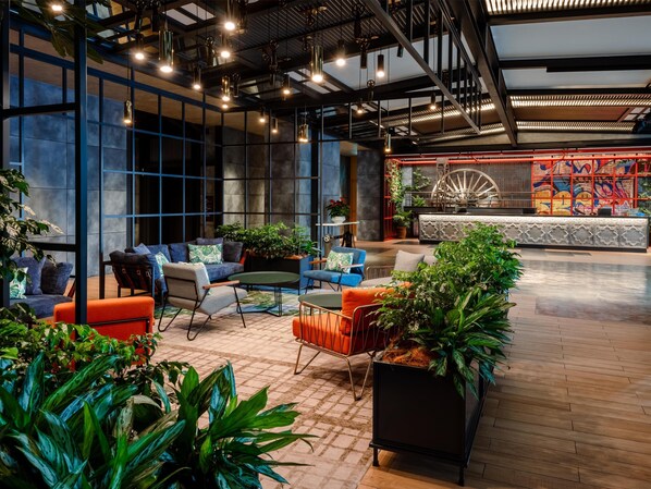 A modern lounge area with seating, plants, and a large decorative wheel. - Hyatt Centric City Centre Kuala Lumpur (Kuala Lumpur)