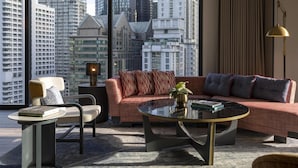 A modern living room with a sofa, armchair, and coffee table, featuring a city view through large windows. - Hyatt Centric City Centre Kuala Lumpur (Kuala Lumpur)