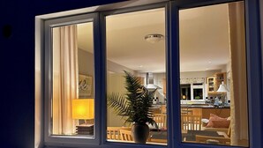 A room with a large window, a potted plant, and a dining area visible through the window. - 4 bedroom detached home close to Kenmare town (Kenmare)