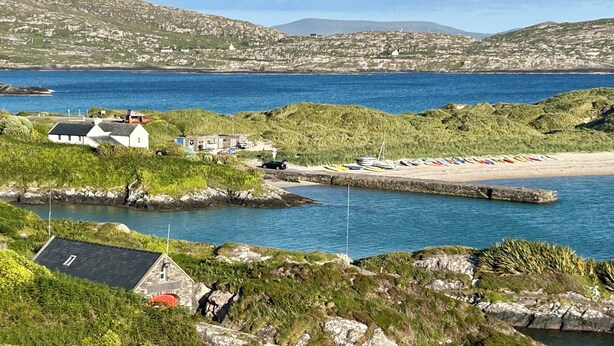 A coastal area with a rocky shoreline, a small harbor, and a row of colorful boats. - 4 bedroom detached home close to Kenmare town (Kenmare)