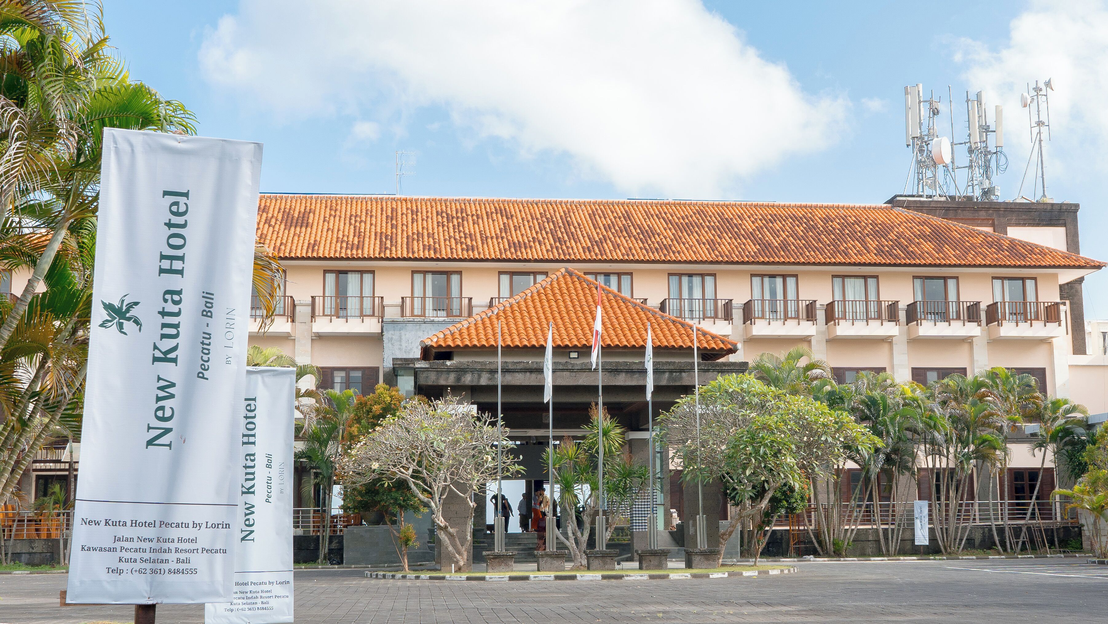 The New Kuta Hotel building with a tiled roof, multiple balconies, and a central entrance.