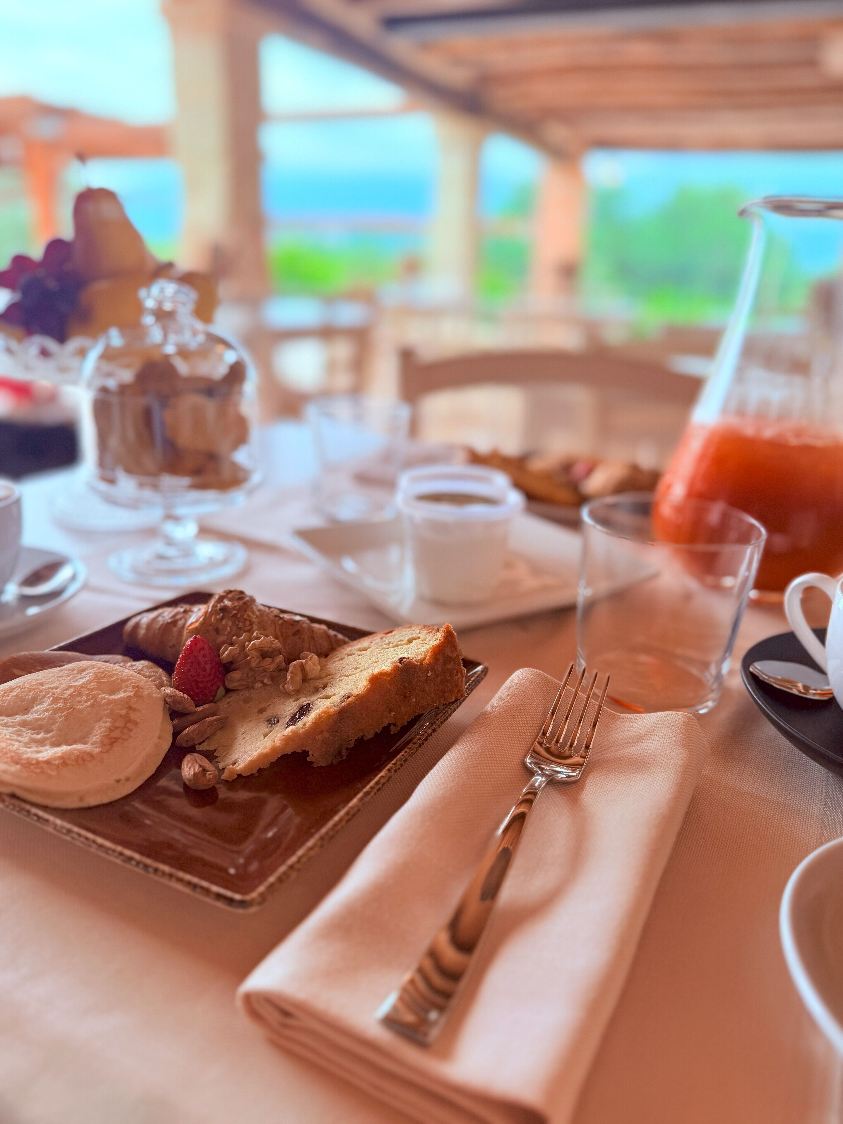 A table set for breakfast with a variety of pastries and a pitcher of juice.