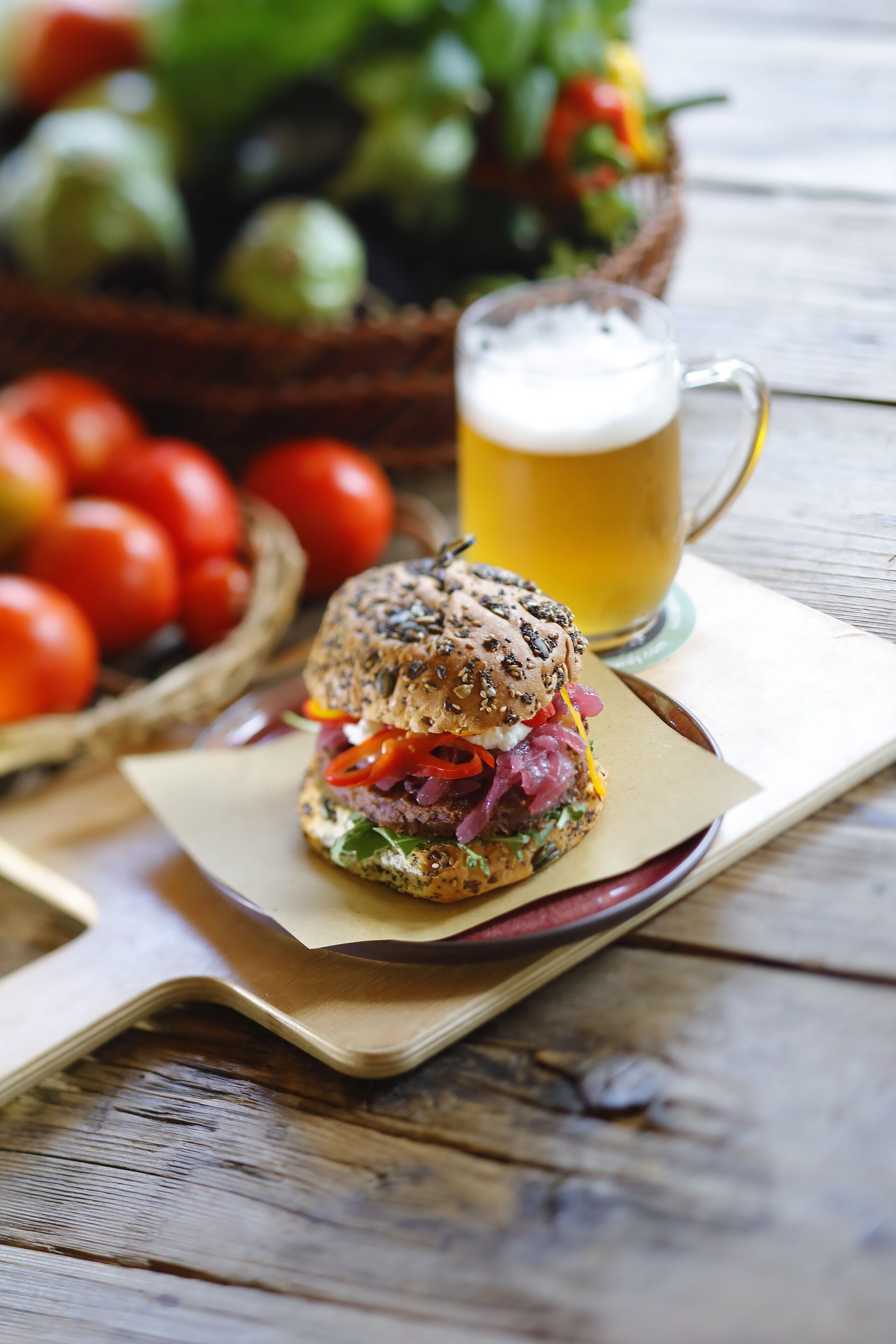 A sandwich on a plate with a beer mug in the background.