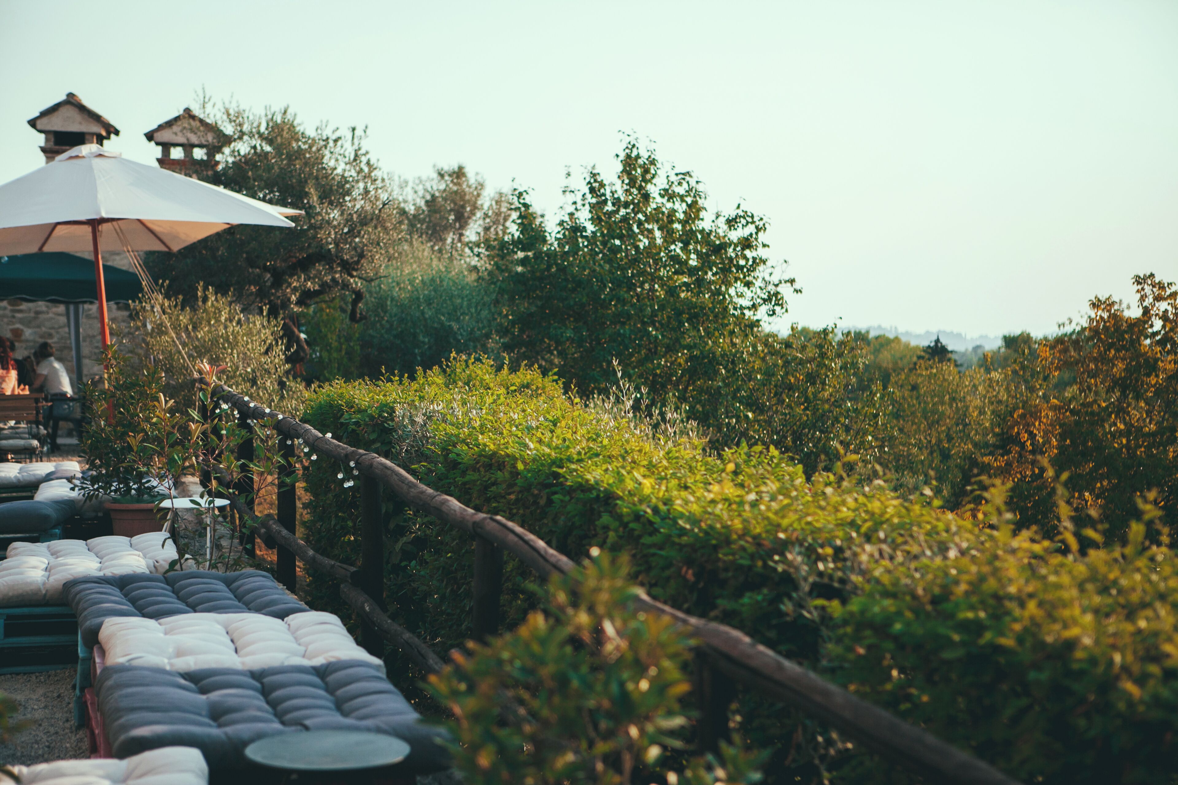 A garden setting with outdoor seating and a rustic fence.