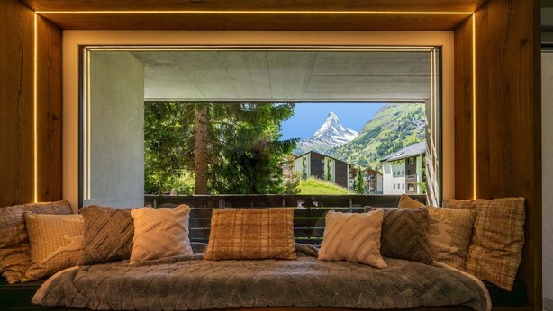 A cozy seating area with a view of a mountain and buildings. - Cervino (Zermatt)