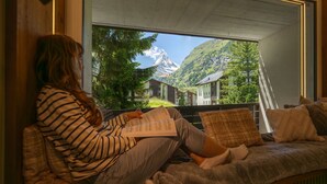 A person sitting on a sofa with a view of a mountain and buildings. - Cervino (Zermatt)