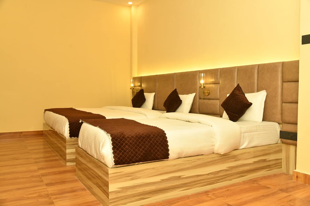 A double bed with a wooden headboard, two bedside tables, and a brown throw blanket.