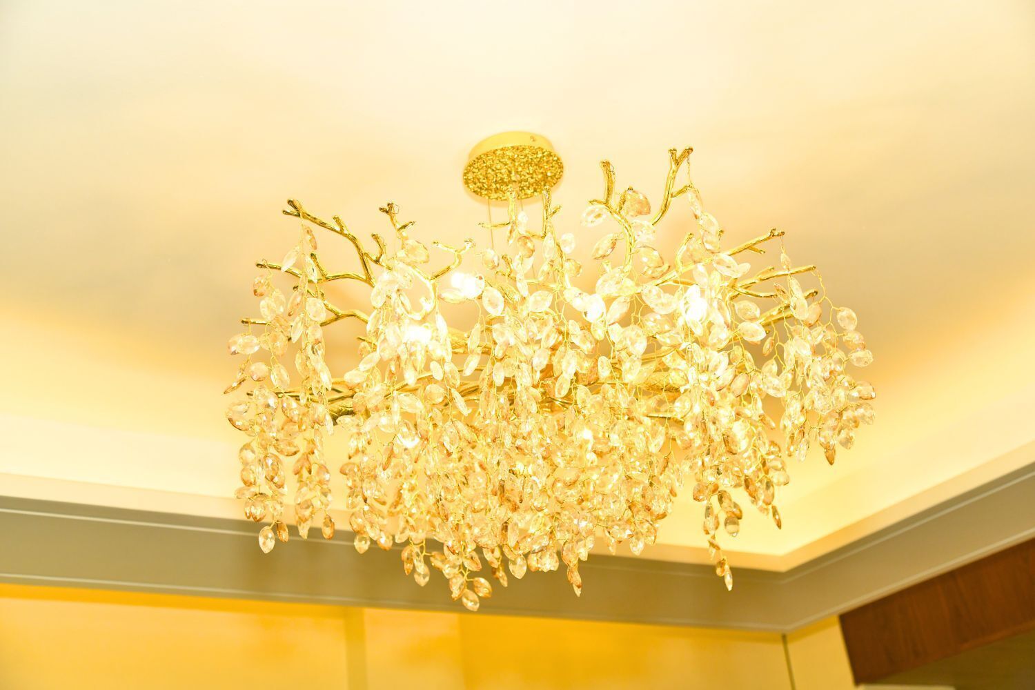 A chandelier with a golden finish and crystal decorations.