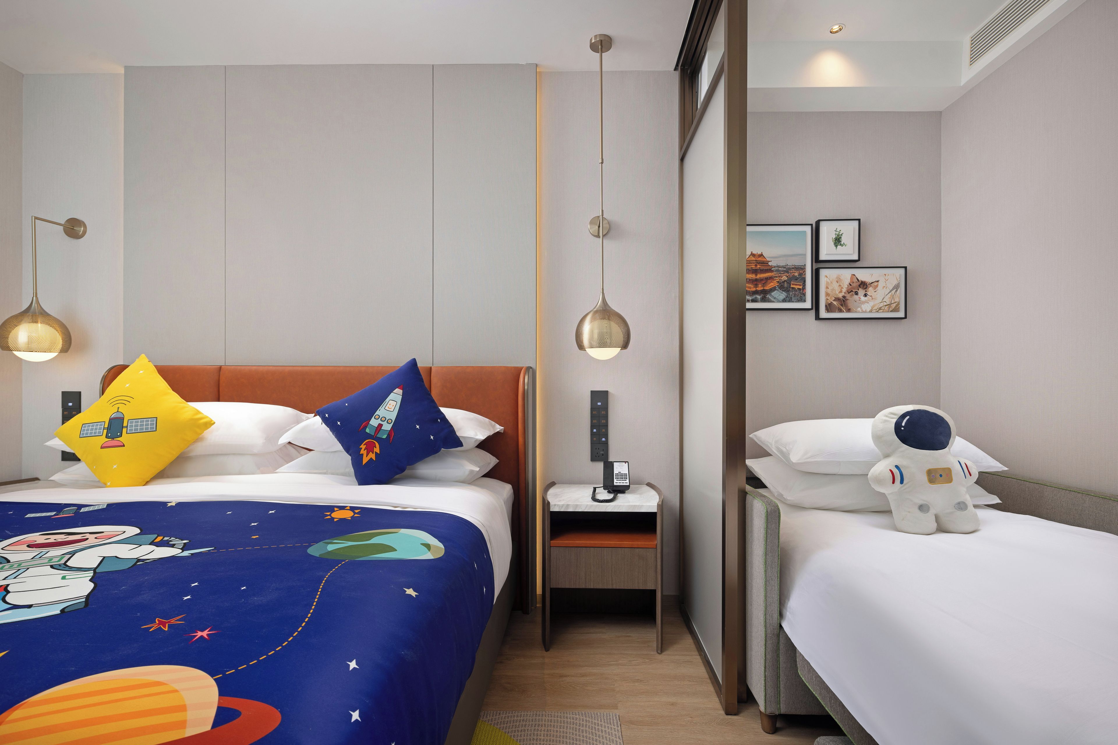 A hotel room with a bed, a nightstand, a wall-mounted phone, and a small table.