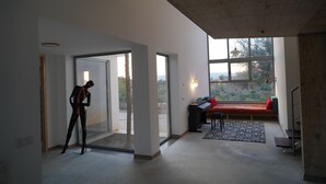 Une pièce spacieuse avec une grande fenêtre, un banc et un mannequin.