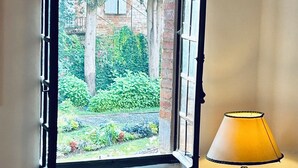 A room with a large window, a radiator, and two armchairs. - La Maison du Prévôt, au Pied de la Cathédrale ! (Albi)