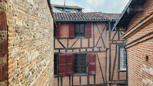 A narrow alleyway with a traditional half-timbered building, a visible antenna, and a clear sky. - La Maison du Prévôt, au Pied de la Cathédrale ! (Albi)