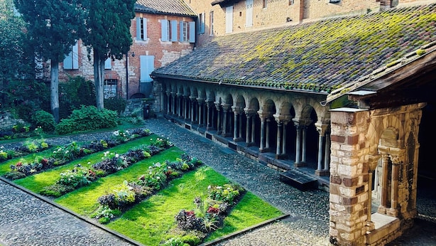A courtyard with a garden, stone pathway, and traditional buildings with brick facades and tiled roofs. - La Maison du Prévôt, au Pied de la Cathédrale ! (Albi)