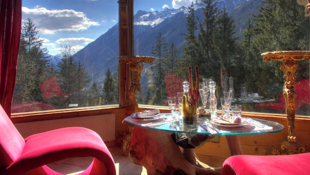 A dining table with glassware and plates, set against a mountain view. - Hôtel Les Chalets de Philippe avec Jacuzzis privatifs (Chamonix-Mont-Blanc)
