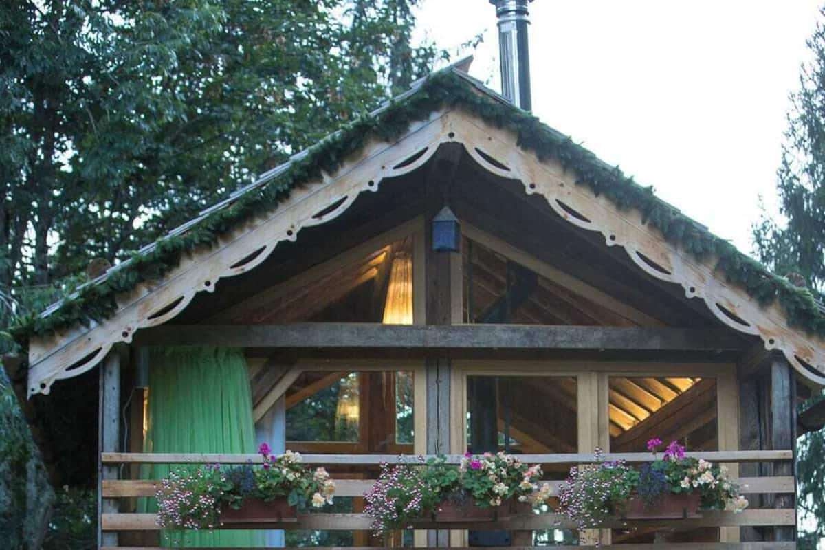 Una baita di legno con un balcone, una scala e una finestra.