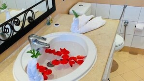 A bathroom with a sink, mirror, and towel rack. - Appart'hotel de charme  (Hammamet)
