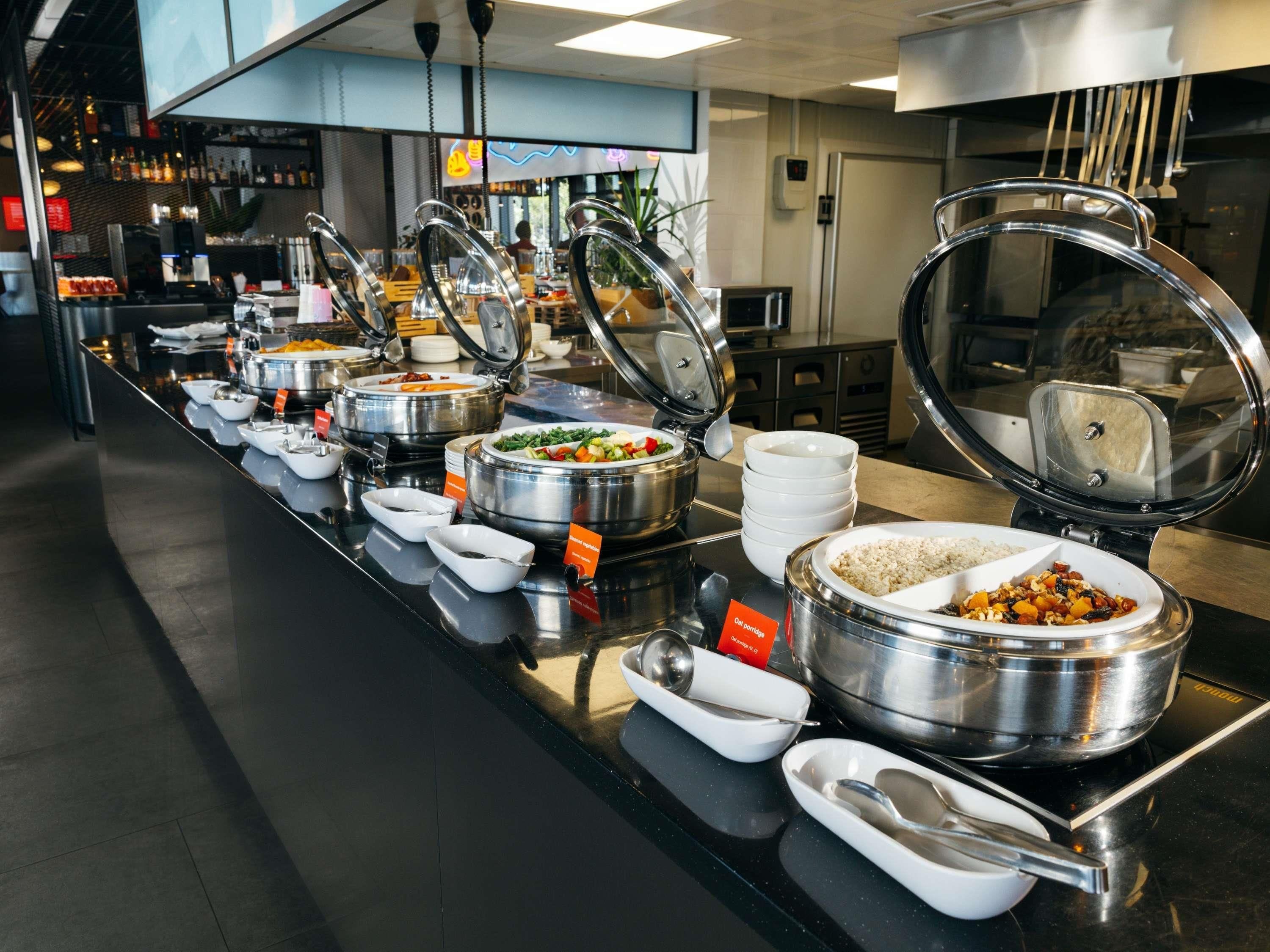 A buffet setup with various food containers and serving utensils.