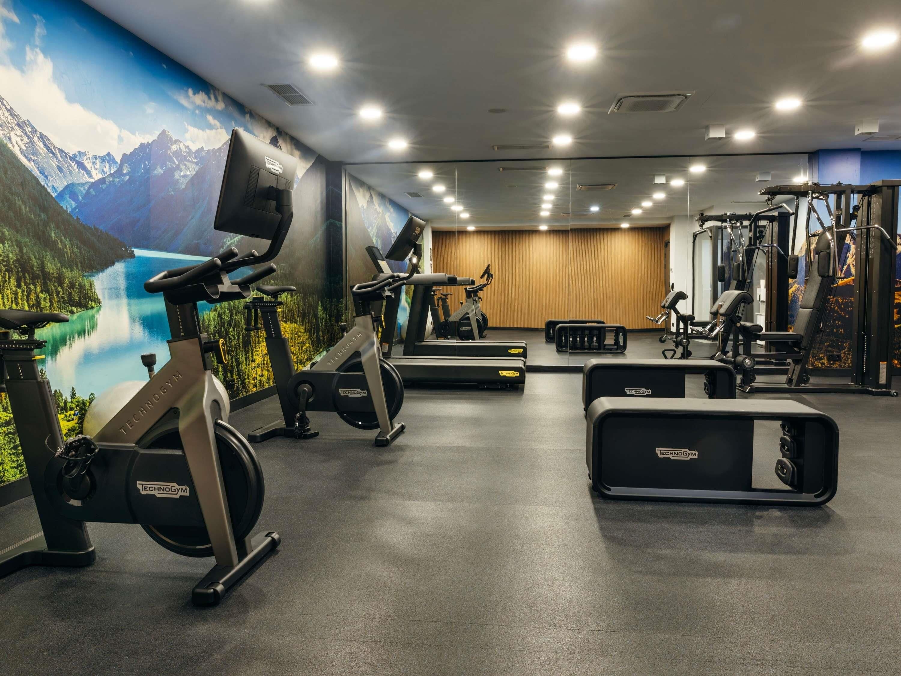 A gym with stationary bikes, a treadmill, and weight machines.