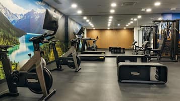 A gym with stationary bikes, a treadmill, and weight machines.