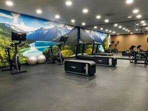 Ein Fitnessstudio mit Ergometer, Laufbändern und Gymbällen.