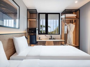 A modern hotel room with a bed, desk, wardrobe, and a large window. - Ibis Tbilisi Airport (Tbilisi)
