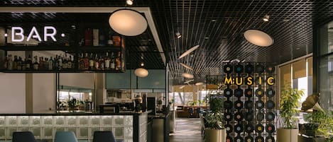 A modern bar area with a 'BAR' sign, a 'MUSIC' section with vinyl records, and seating with a glass partition.