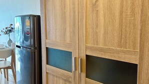 A kitchen with a wooden cabinet and a black refrigerator.