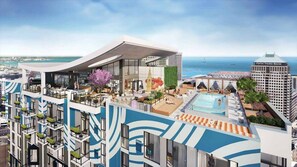 Et moderne hotel med en pool på taget, udendørs siddepladser og havudsigt.