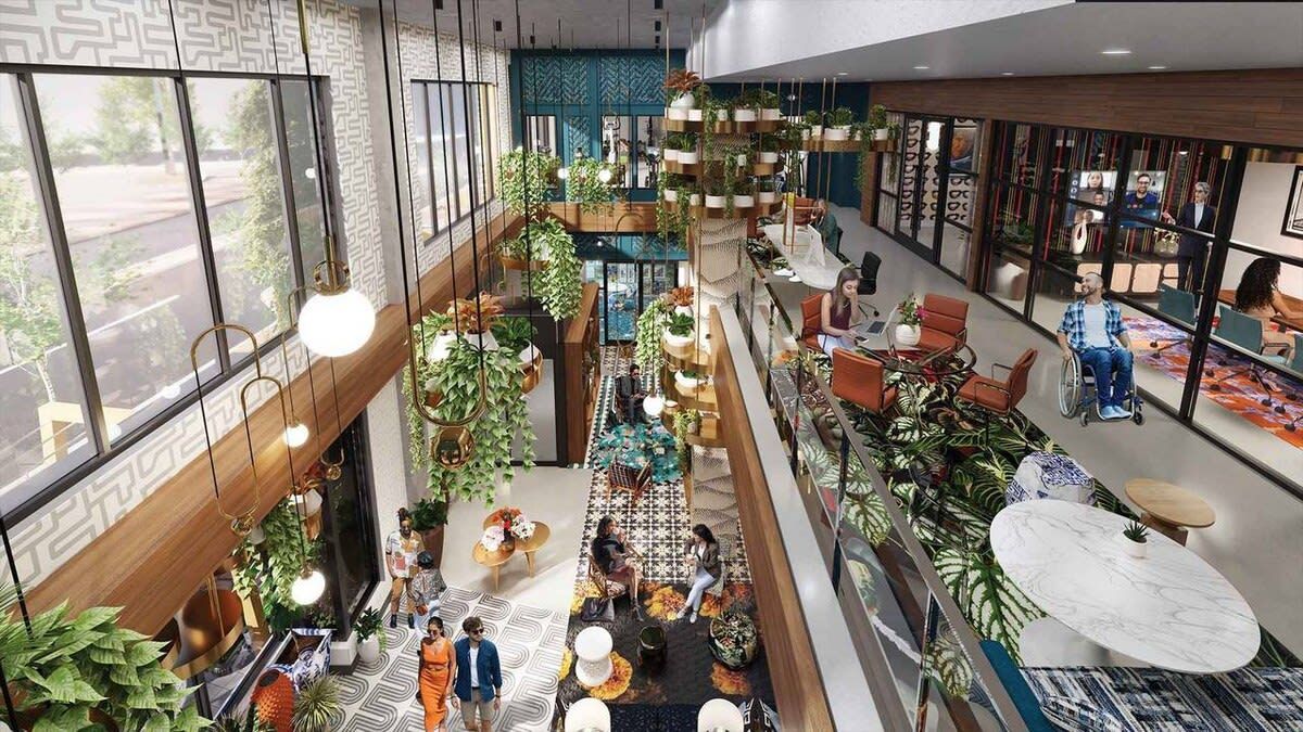 Un vaste espace intérieur comprenant plusieurs coins salon, des plantes et une vue sur l’extérieur grâce à de grandes fenêtres.