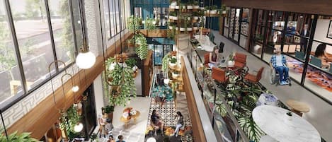 Een ruime binnenruimte met meerdere zithoeken, planten en uitzicht op het buitenleven door grote ramen.