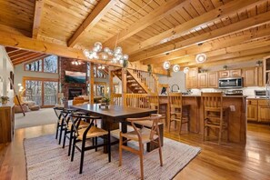 A spacious kitchen with wooden cabinets, a large island, and a dining area with a wooden table and chairs.