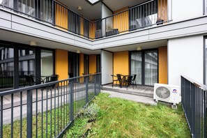 Ein modernes Gebäude mit Innenhof, Außenbestuhlung und Klimaanlage.