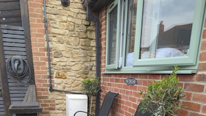 An outdoor seating area with two black chairs and a potted plant. - The Orchid (Gillingham)