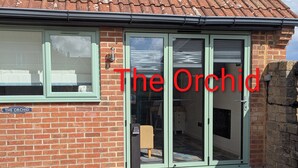 A brick building with a sign reading "The Orchid" and a key box post in front. - The Orchid (Gillingham)