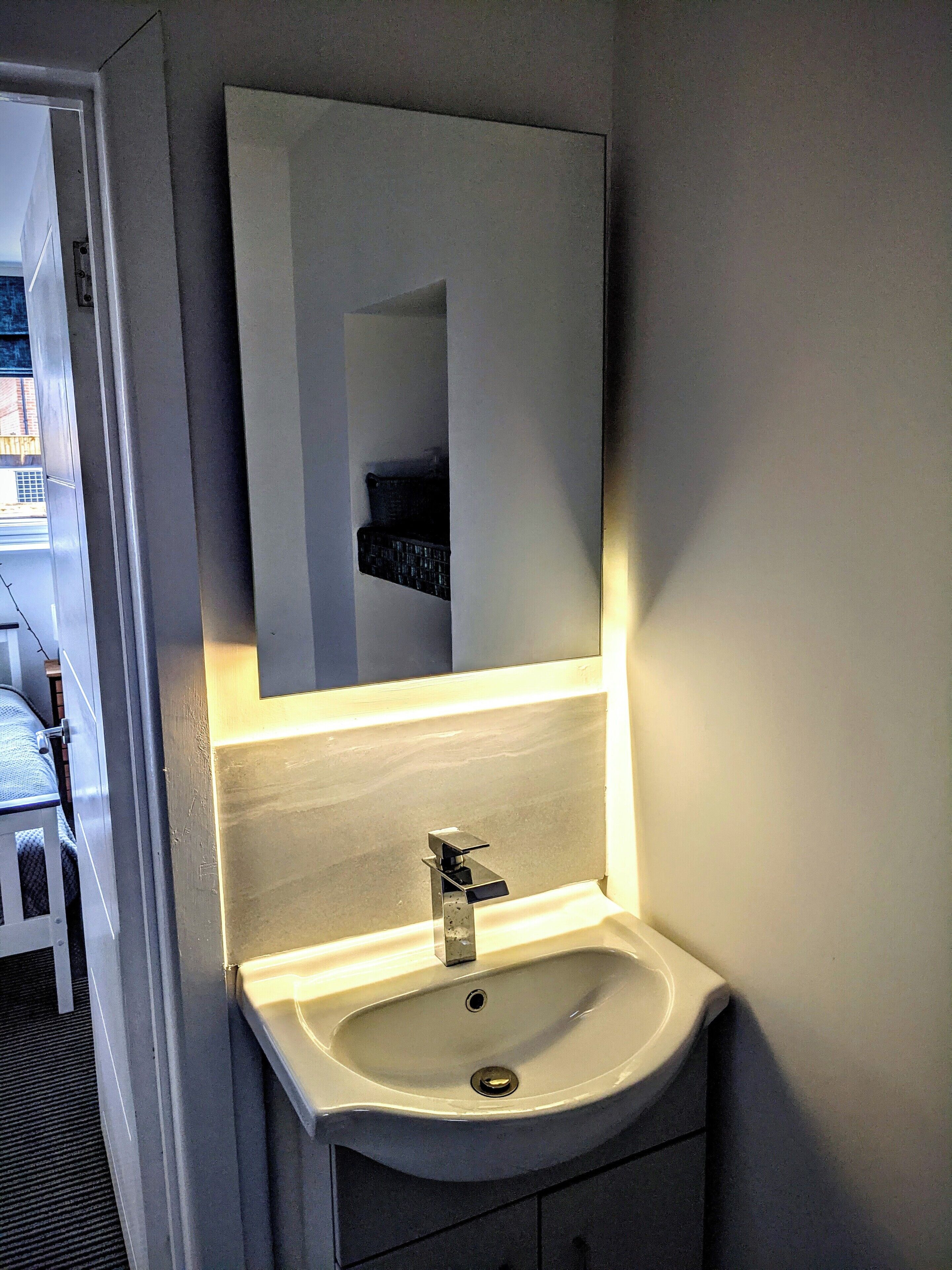 Ein Badezimmer mit Waschbecken, Spiegel und Handtuchhalter.