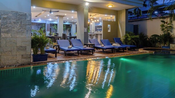 A poolside area with lounge chairs and a pool.