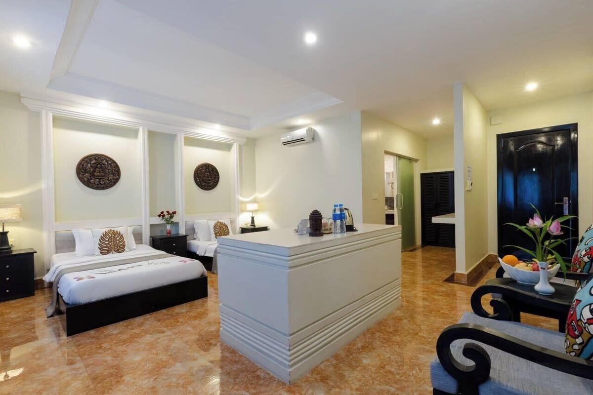 Una habitación de hotel con una cama grande, un escritorio y una zona de estar con una mesa y sillas.
