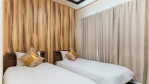 A hotel room with two beds, wooden paneling on the wall, and beige curtains. - Daiyamondo Yui Ooyamaten (Tokyo)