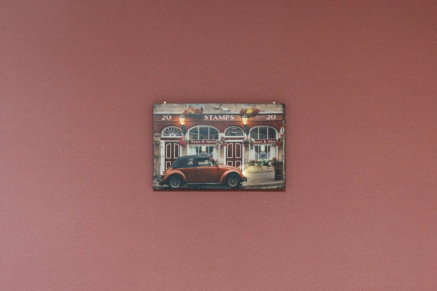 A vintage-style building with a vintage car parked in front.