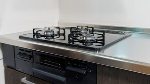 A kitchen with a gas stove, a dishwasher, and a microwave. - Daiyamondo Yui Ooyamaten (Tokyo)