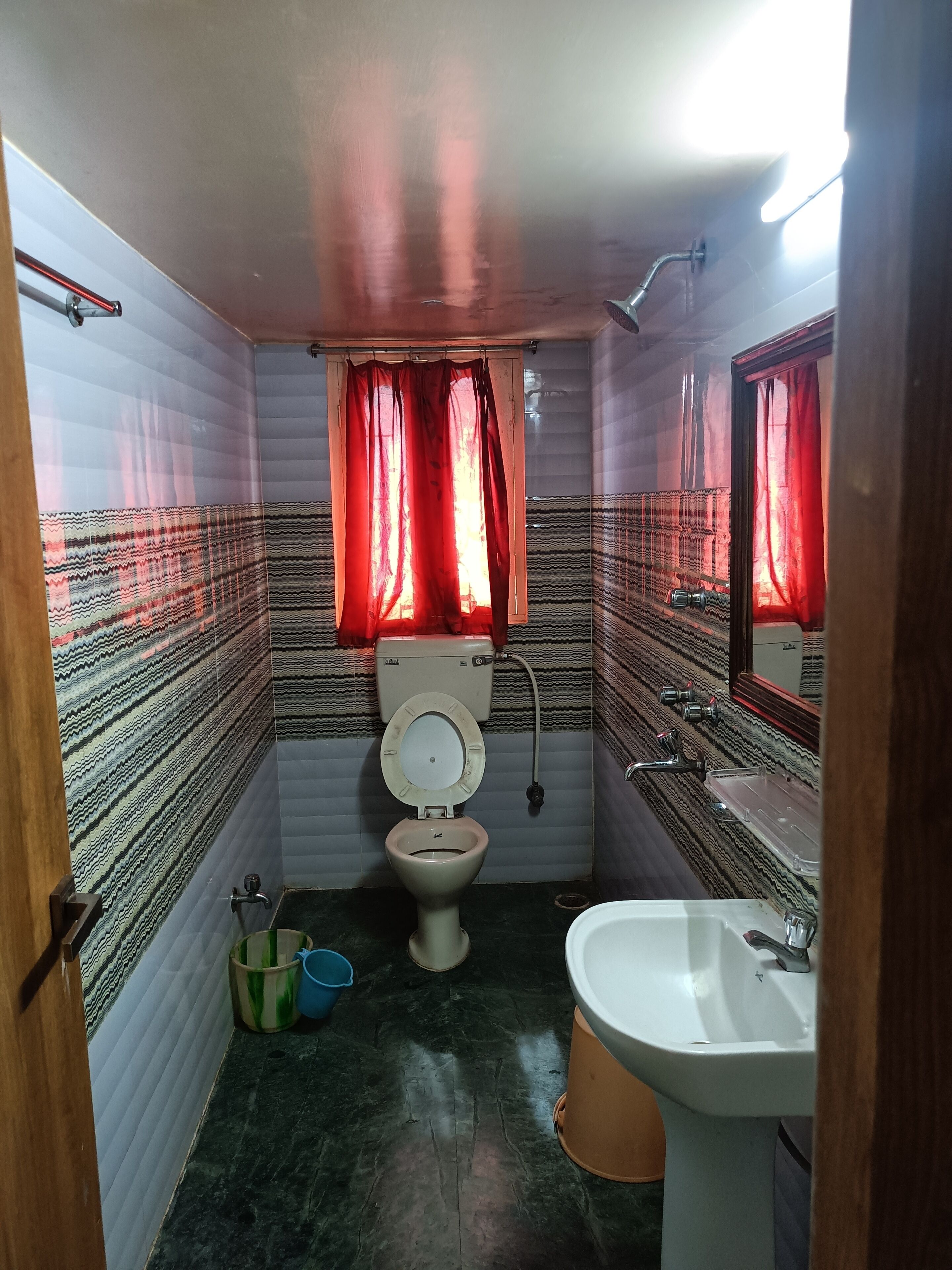 A small bathroom with a toilet, sink, and shower.