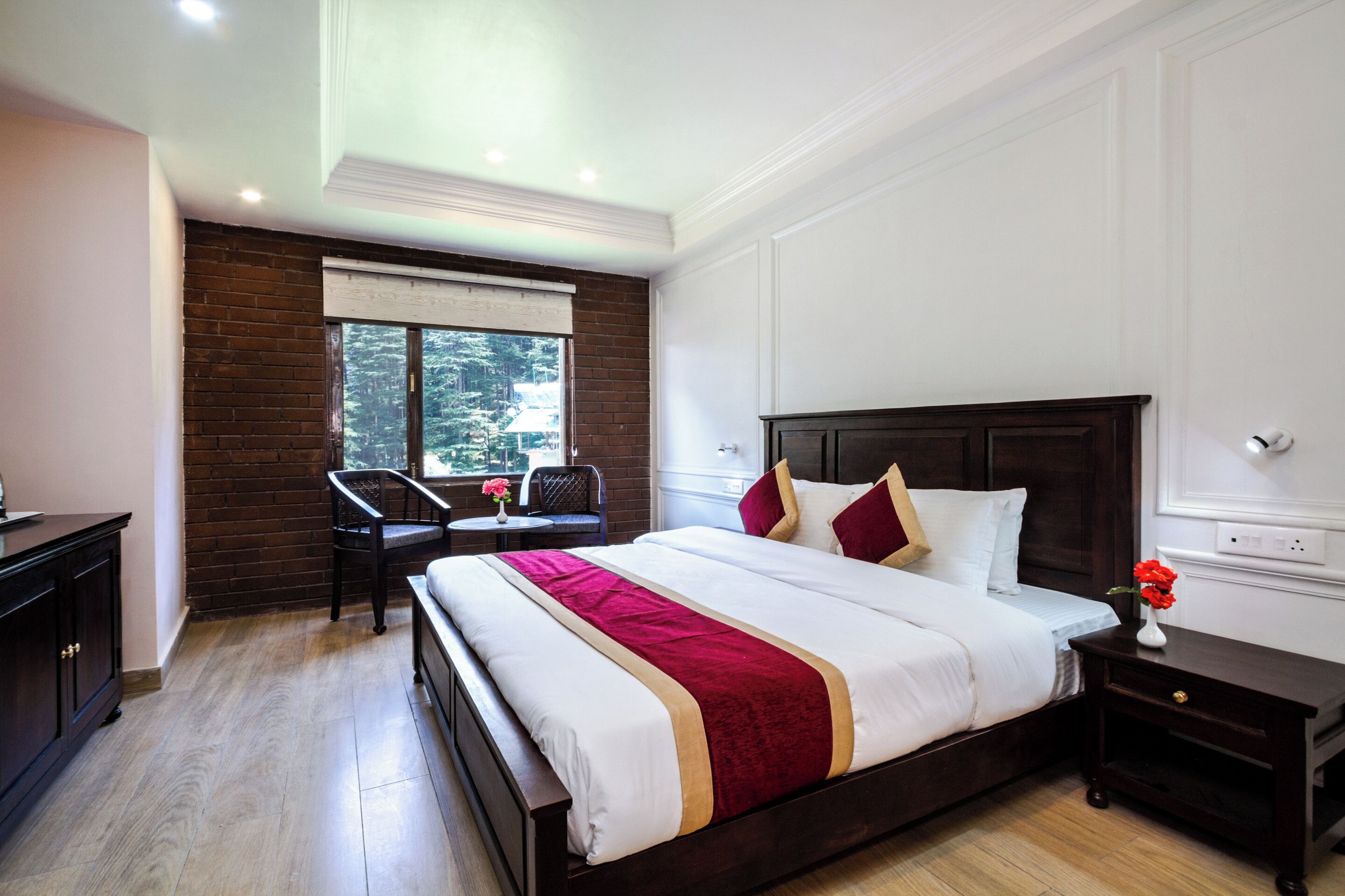 A hotel room with a large bed, a desk, and a chair.