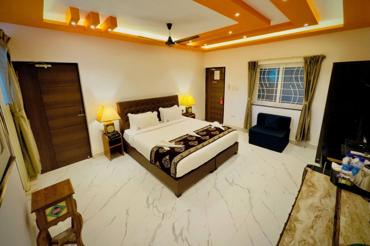 A modern bedroom with a large bed, a ceiling fan, and a window with curtains.
