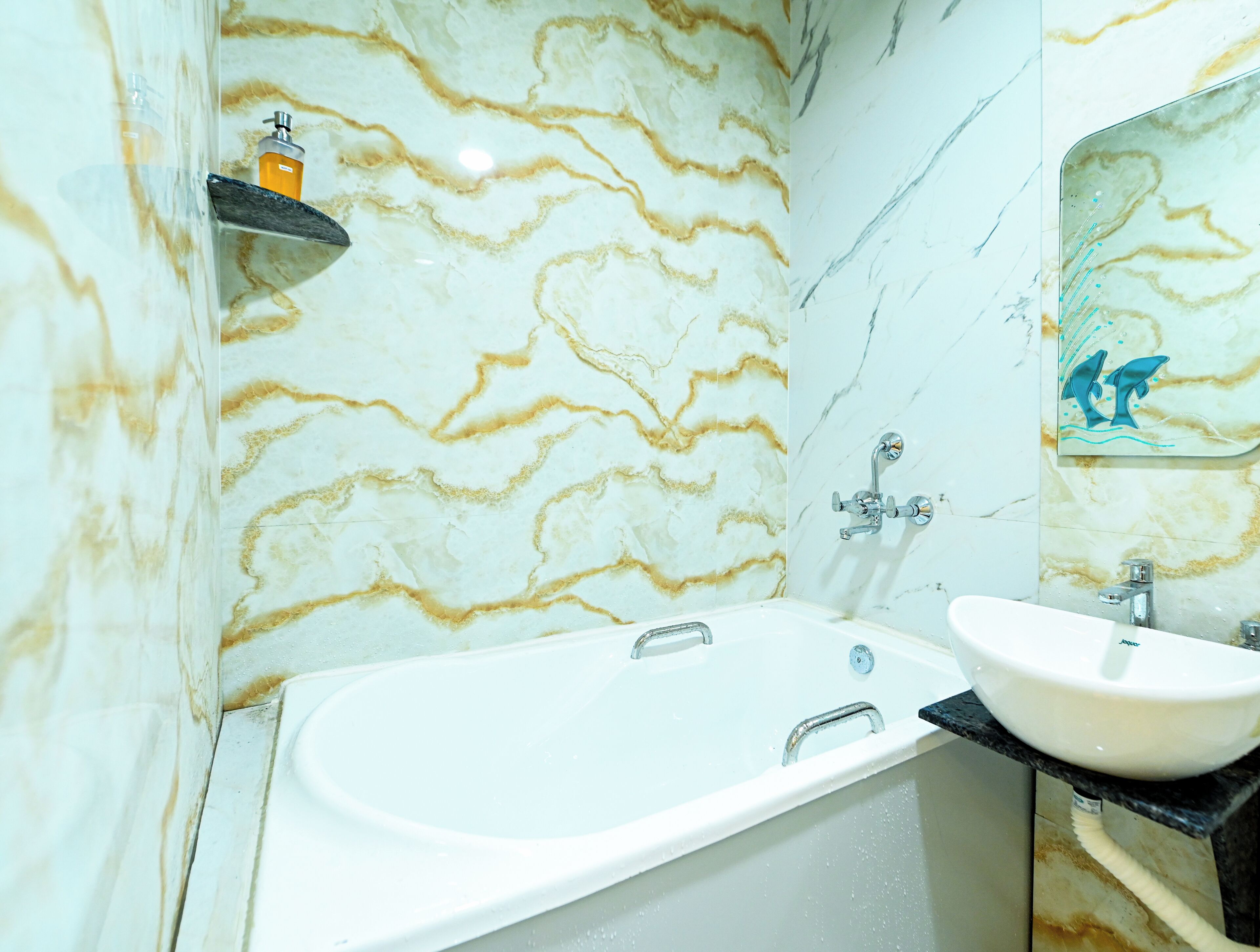 A bathroom with a bathtub, a sink, and a marble wall with a wavy pattern.
