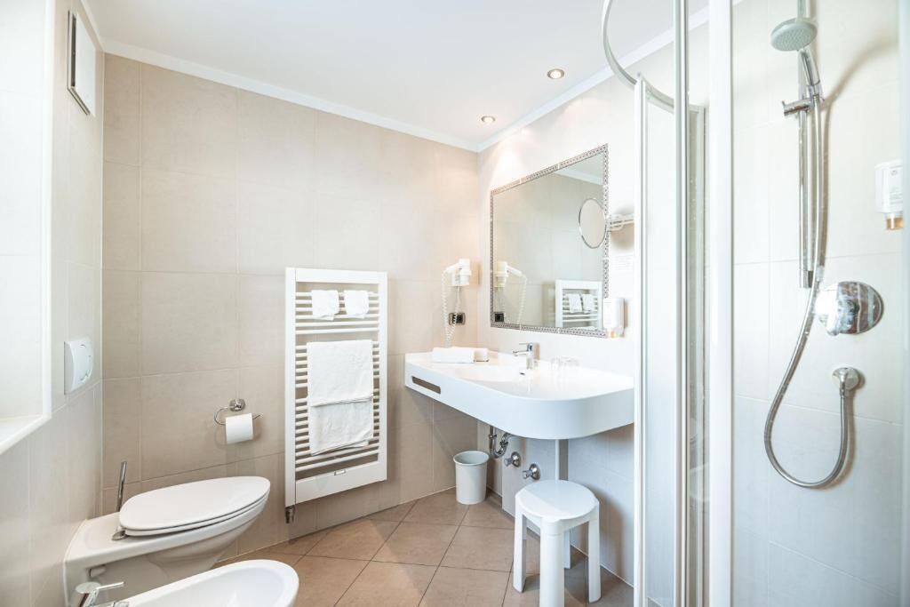 A modern bathroom with a toilet, sink, and shower.