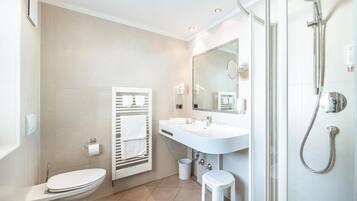A modern bathroom with a toilet, sink, and shower.