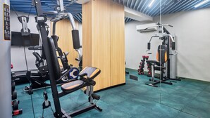 A gym with exercise equipment, a wooden wall, and a ceiling with blue lighting. - Holiday Inn Express & Suites Vijayawada by IHG (Vijayawada)