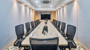 A conference room with a long table, chairs, water bottles, and a TV screen. - Holiday Inn Express & Suites Vijayawada by IHG (Vijayawada)