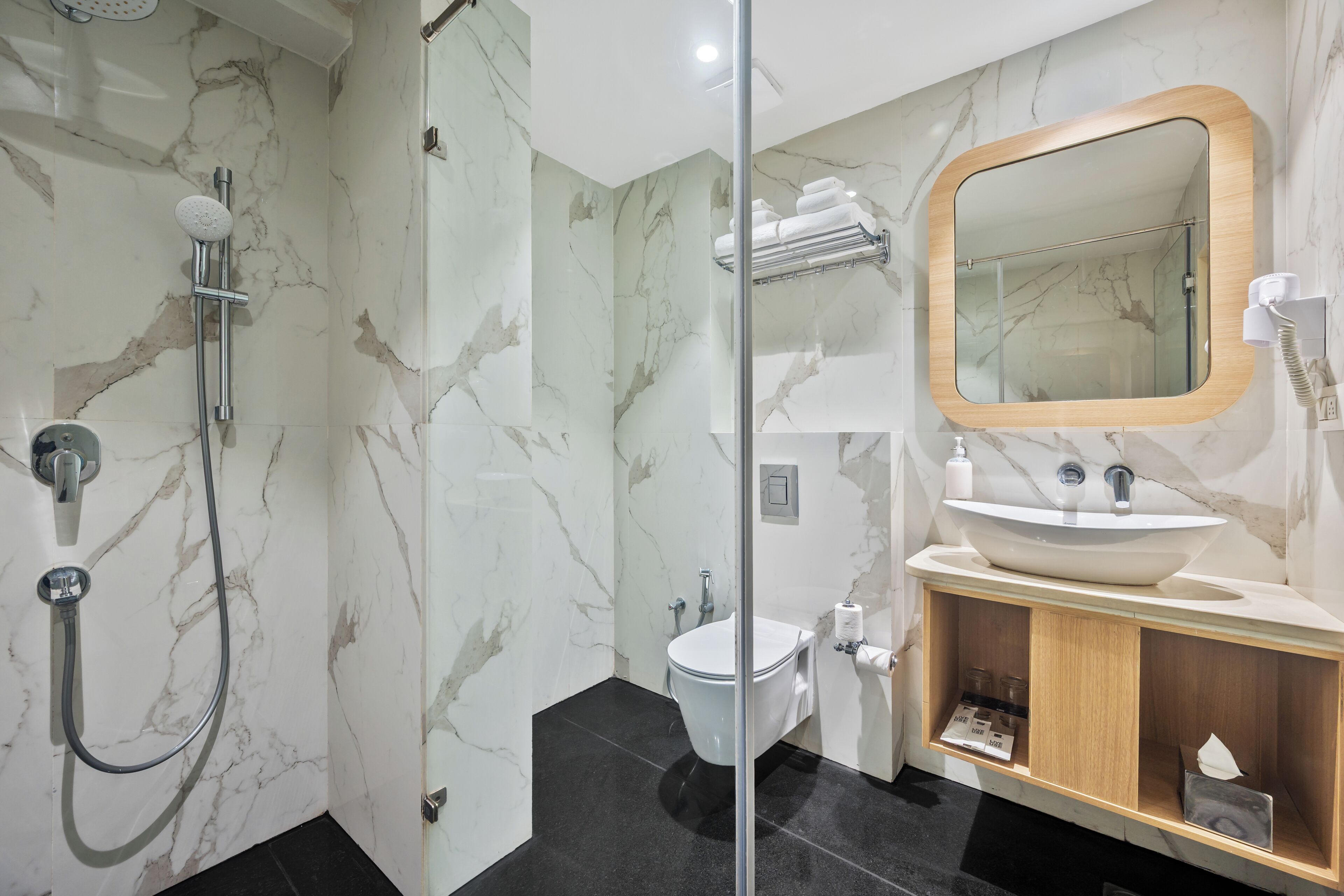 A bathroom with a shower, toilet, sink, and a mirror.