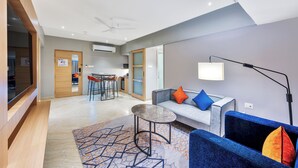 En modern hotellobby med en sittgrupp, ett litet bord och en soffa med kuddar.